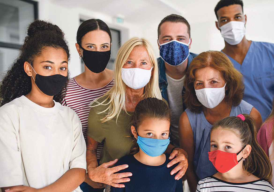 Menschen verschiedenster Alter und Ethnien mit Coronamasken schauen in die Kamera